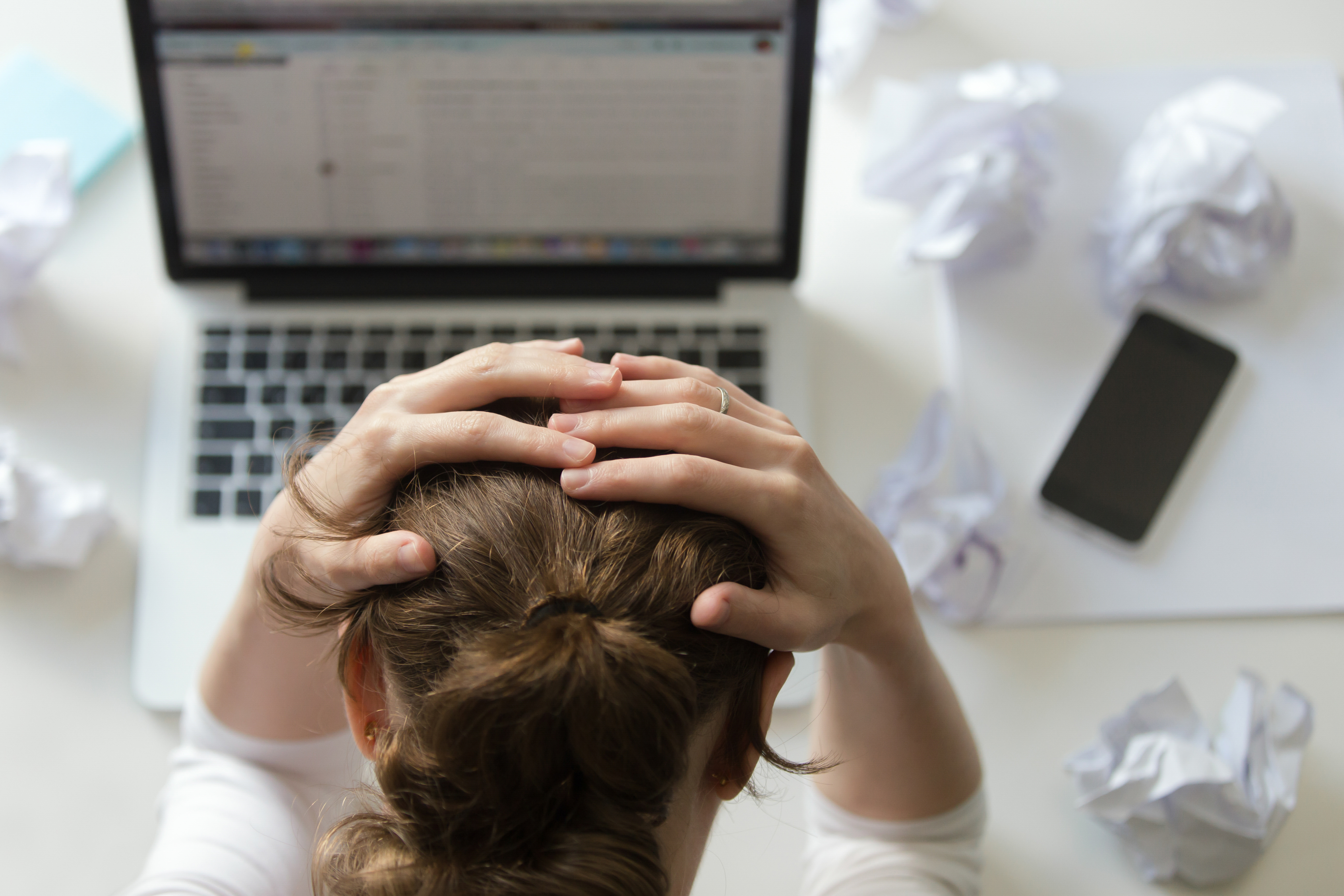 portrait-woman-grabbing-head-desk-near-laptop.jpg